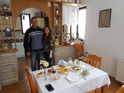 a man and woman standing next to a table with food at Pansion Izvor in Korenica