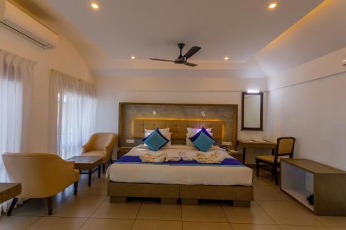 a bedroom with a bed and a table and chairs at Kappad Beach Resort in Kappad