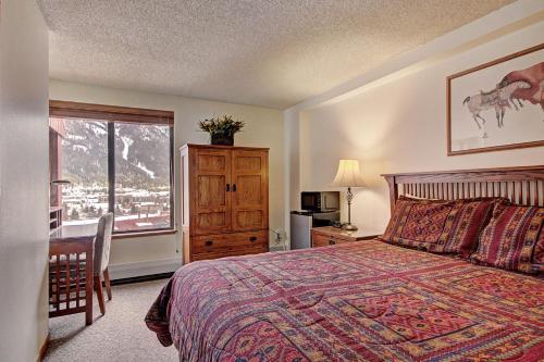 a bedroom with a bed and a desk and a window at VS643 Square Condo in Copper Mountain