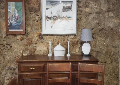 a wooden desk with a lamp and a table with chairs at Trajadinha - Casa da Travessa in Caminha