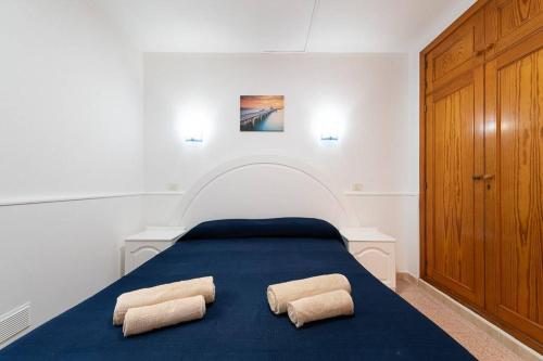 1 dormitorio con 1 cama azul y 2 almohadas en Huertas del Nublo Vivienda Vacacional, en Puerto Rico de Gran Canaria