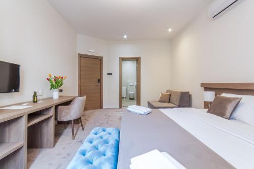 a bedroom with a large bed and a desk and a computer at M House Belgrade Residence in Belgrade