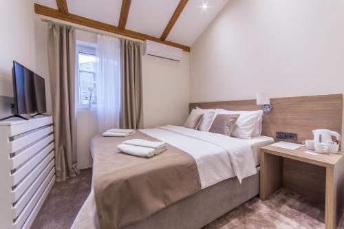 a bedroom with a large bed and a television at M House Belgrade Residence in Belgrade