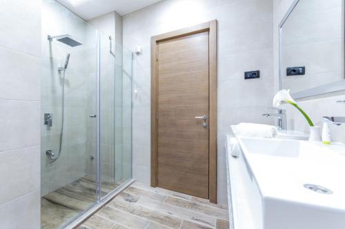 a bathroom with a glass shower and a sink at M House Belgrade Residence in Belgrade