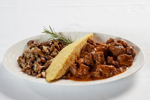 a plate of food with meat and a piece of bread at Albergo Aurora in Vignola