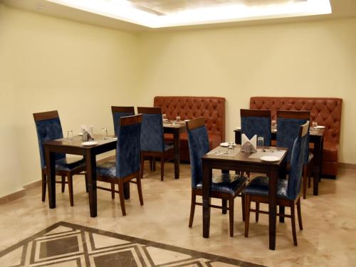 a dining room with wooden tables and chairs at Clarks Inn Suites Katra in Katra