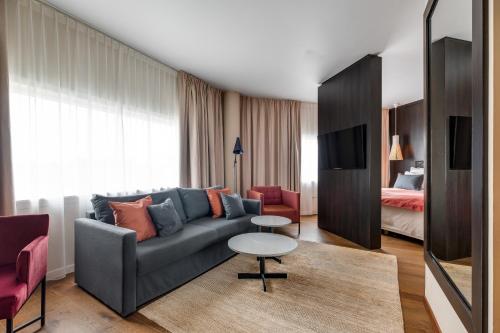 uma sala de estar com um sofá, uma mesa e uma cama em Quality Airport Hotel Stavanger em Sola