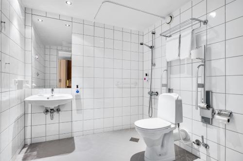 a white bathroom with a toilet and a sink at Quality Airport Hotel Stavanger in Sola