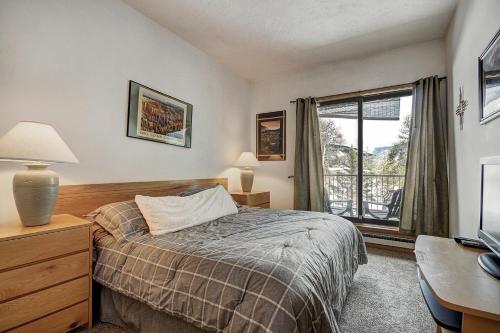 a bedroom with a bed and a desk and a window at 2062 The Pines Condo in Keystone