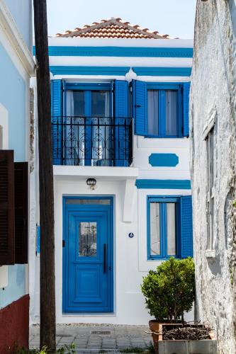a blue door on a white building with a balcony at Koskinou Traditional Houses in Koskinou