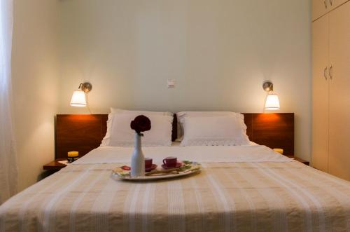 uma cama com um prato com uma flor num vaso em Villa O em Melíssion
