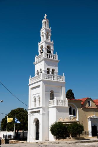 a tall white tower in front of a building at Koskinou Traditional Houses in Koskinou