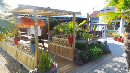 une terrasse en bois avec des plantes et une pergola dans l'établissement Casa Bihan Ty Coat, à Lannion