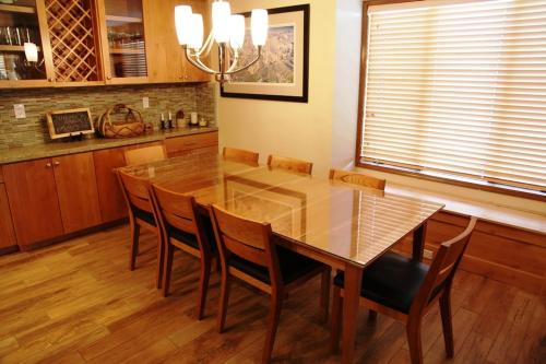 a dining room with a glass table and chairs at Sierra Megeve #7 Condo in Mammoth Lakes