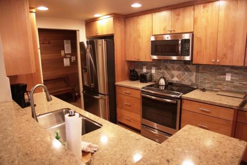 a kitchen with stainless steel appliances and wooden cabinets at Sierra Megeve #7 Condo in Mammoth Lakes