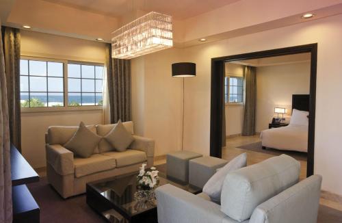 a living room with a couch and a bed and a mirror at Move On Beach Resort Al Khobar in Half Moon Bay