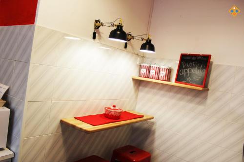 una habitación con una mesa con un cuenco rojo en un estante en Sa Domu de Ajaja Apartments, en Cagliari