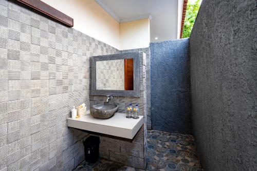 a bathroom with a sink and a mirror at Pemuntalan Guesthouse in Nusa Lembongan
