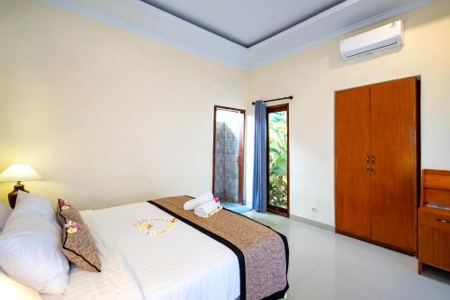 un dormitorio con una cama y una ventana en Pemuntalan Guesthouse, en Nusa Lembongan