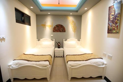 two beds in a small room with a ceiling at DuGu Hostel in Jinning
