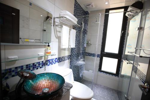 a bathroom with a sink and a toilet and a window at DuGu Hostel in Jinning