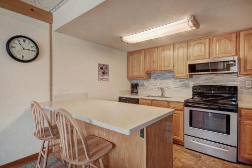 a kitchen with a counter and a clock on the wall at Sh404 Summit House Condo in Copper Mountain