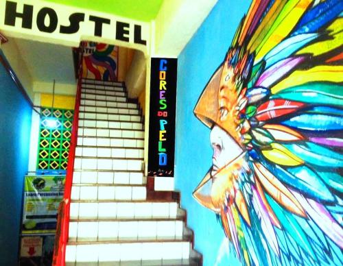 Habitación con escalera y pared con mural. en Hostel Cores do Pelô en Salvador