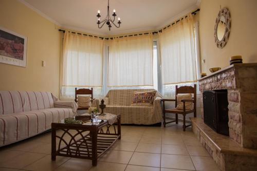 a living room with a couch and a fireplace at Villa O in Melíssion