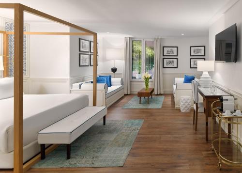 a bedroom with a bed and a living room at H10 Duque de Loule in Lisbon