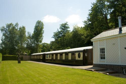 Ein Zug parkt auf einem Hof neben einem Haus. in der Unterkunft The Old Railway Station in Petworth