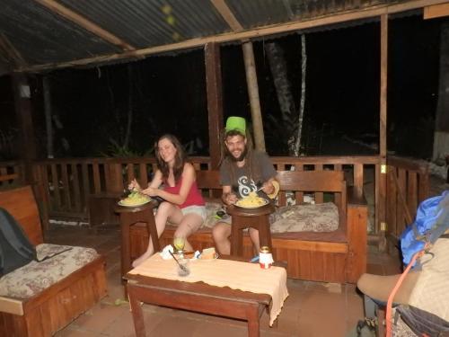 a man and a woman sitting on a bench with food at Nawal in Lanquín