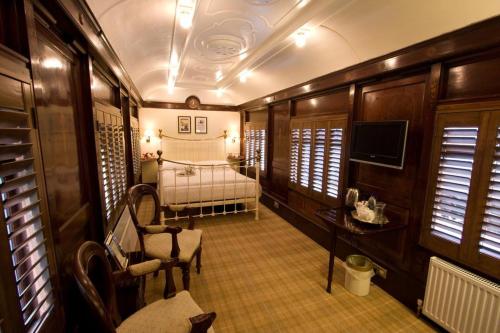 a train room with a bed and a television at The Old Railway Station in Petworth
