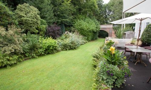 a garden with a lawn with a table and chairs at The Old Railway Station in Petworth