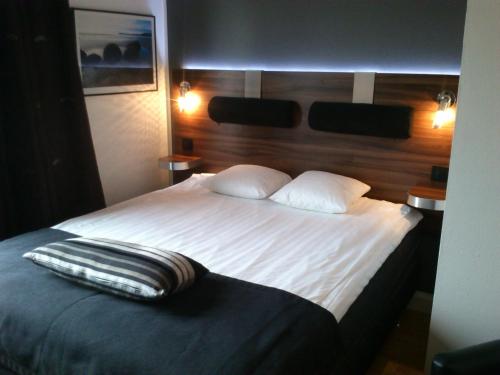a bedroom with a large bed with white sheets and pillows at Hotell Östersund in Östersund