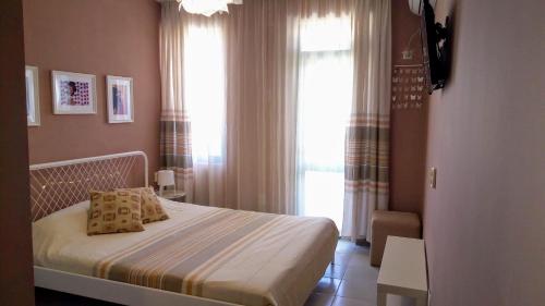 een slaapkamer met een bed en een groot raam bij Ethno guest suite in Primorsko