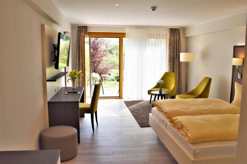 オーバーキルヒにあるHotel-Gasthof Roseのベッドとテーブルと椅子のあるホテルの部屋