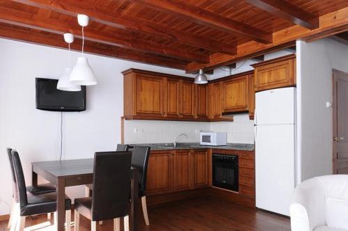 a kitchen with a table and a white refrigerator at Apartamentos Rentarán in Tredós