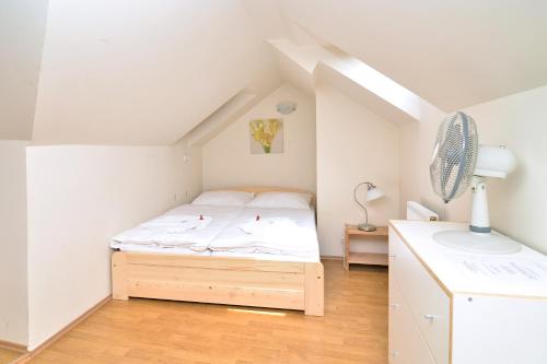 ein kleines Schlafzimmer mit einem Bett im Dachgeschoss in der Unterkunft Historic Centre Apartments VIII in Prag