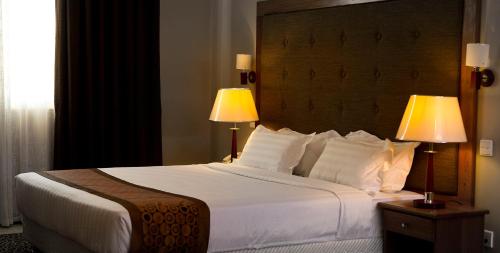 a bedroom with a large white bed with two lamps at Seascape Hotel in Dar es Salaam