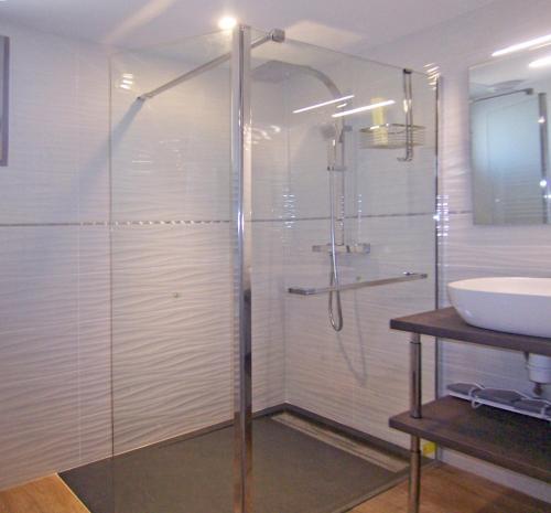 La salle de bains est pourvue d'une douche en verre et d'un lavabo. dans l'établissement Nid d'Arguin, à La Teste-de-Buch