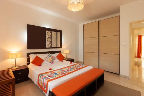 a bedroom with a large bed with orange pillows at Praslin Paradise in Baie Sainte Anne