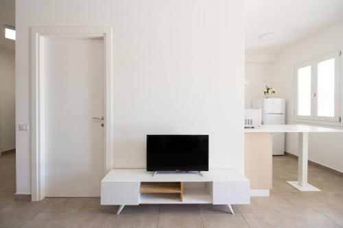 a living room with a tv on a white cabinet at Appartamenti Shardana in Villasimius