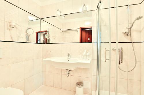 a white sink sitting under a mirror in a bathroom at Hotel Amber Design in Krakow