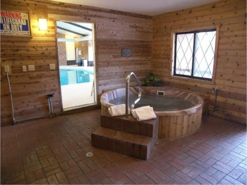 un gran baño de madera con bañera y piscina en Bavarian Haus Lakefront Inn, en Saint Ignace