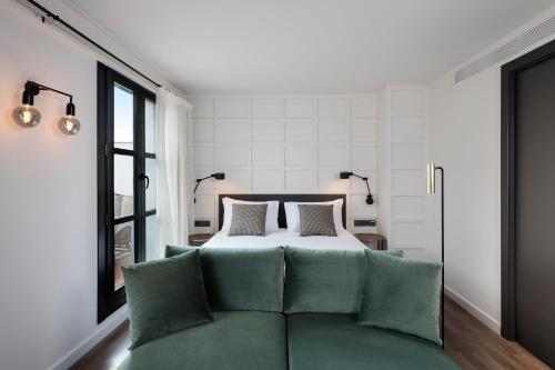 Un pat sau paturi într-o cameră la Yurbban Ramblas Boutique Hotel