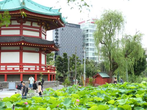 a pagoda in a city with people walking in a garden at APA Hotel Keisei Ueno Ekimae in Tokyo