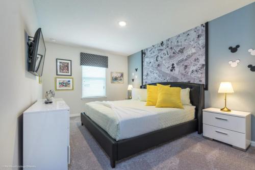 - une chambre avec un lit doté d'oreillers jaunes et une télévision dans l'établissement Orlando Newest Resort Community Town Home Townhouse, à Orlando