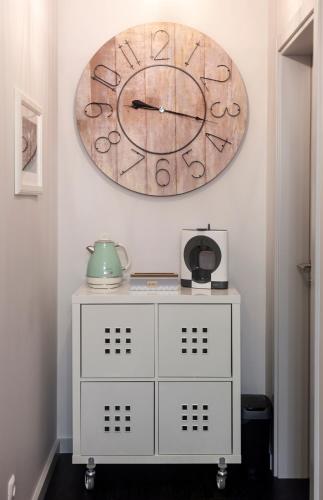 a large clock hanging on a wall above a dresser at My Bed in pico in Madalena