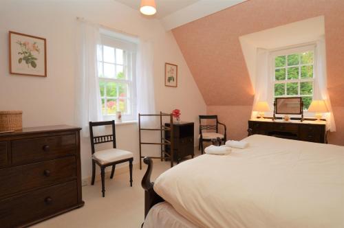 a bedroom with a bed and a desk and two chairs at Rhoda`s Cottage in Creggans
