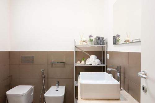 a bathroom with a white sink and a toilet at Appartamenti Shardana in Villasimius